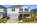 Two-story house with gray siding, stone accents, and a two-car garage at 583 Taft Dr, Davenport, FL 33837