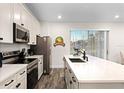 Modern kitchen featuring white cabinets, stainless steel appliances, and a large island at 8178 Coconut Pl, Kissimmee, FL 34747