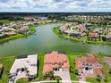 Community overview featuring lakefront homes and lush landscape at 880 Spinnaker Way, Kissimmee, FL 34746