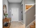 Bright and airy foyer with tile flooring, a wooden console table, and stairway at 8963 Coco Palm Rd, Kissimmee, FL 34747