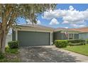 House with a green garage door, landscaping, and American flag at 102 Circle Hill Rd, Sanford, FL 32773