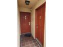Shared entryway with two red doors and tile flooring at 10232 Turkey Lake Rd # 181, Orlando, FL 32819