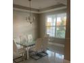 Bright dining room with a glass table, white chairs, and a chandelier at 14429 Wabasso Loop, Winter Garden, FL 34787