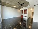 Open concept living area with dark tile floors and exposed ceilings at 155 S Court Ave # 1603, Orlando, FL 32801