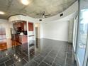 Open concept living area with dark tile floors and exposed ceilings at 155 S Court Ave # 1603, Orlando, FL 32801