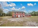 Two-story brick home with a large yard and a partly cloudy sky at 1960 Murray Rd, Fort Meade, FL 33841