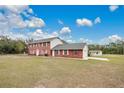 Two-story brick home with a large yard, detached garage and a partly cloudy sky at 1960 Murray Rd, Fort Meade, FL 33841