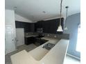 Modern kitchen with dark cabinets and stainless steel appliances at 228 Whispering Pines Way, Davenport, FL 33837