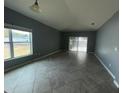 Spacious living room with tile flooring and sliding glass doors leading to the patio at 228 Whispering Pines Way, Davenport, FL 33837