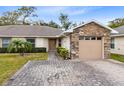 Inviting exterior with stone accents and a paved driveway at 2717 Shelby Ruth Pl, St Cloud, FL 34769