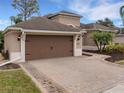 Two-car garage with brown doors and a paved driveway at 296 Del Sol Ave, Davenport, FL 33837