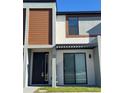 Townhome entrance with modern gray door and brown siding at 3237 Energy Drive, Kissimmee, FL 34747