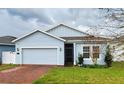 Cute light blue house with a red brick driveway and a two-car garage at 421 Disa Dr, Davenport, FL 33837