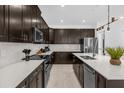 Modern kitchen with dark cabinetry, stainless steel appliances, and white countertops at 4370 Rhyme St, Kissimmee, FL 34746