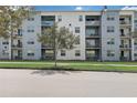 Apartment building exterior showcasing multiple balconies and a tree at 4741 Clock Tower Dr # 306, Kissimmee, FL 34746