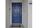 Stylish blue front door with welcome mat at 4741 Clock Tower Dr # 306, Kissimmee, FL 34746