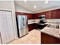 Modern kitchen featuring stainless steel appliances and dark wood cabinets at 505 Pentas Ln, Haines City, FL 33844