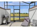 Relaxing screened patio with grill and lounge chair overlooking the lake at 8985 Stinger Dr, Davenport, FL 33896