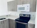Modern kitchen with gray cabinets, white countertops, and stainless steel appliances at 1240 S Beach Cir, Kissimmee, FL 34746