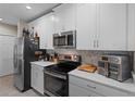 White kitchen features stainless steel appliances and quartz countertops at 1254 Wispy Cypress Dr, Kissimmee, FL 34746