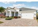 White single-story house with a paver driveway and palm trees at 2937 Bella Flore Ter, New Smyrna Beach, FL 32168