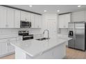 Modern kitchen featuring white cabinets, stainless steel appliances, and a large island at 3142 Viceroy Ct, Poinciana, FL 34759