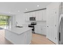 Modern kitchen with white cabinets, stainless steel appliances, and an island at 3142 Viceroy Ct, Poinciana, FL 34759