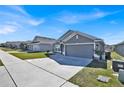 Street view of gray single-story home with well-kept lawn and manicured landscaping at 434 Panaro Ln, Haines City, FL 33844