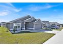 Street view of a gray single-story home with well-kept lawn and minimal landscaping at 434 Panaro Ln, Haines City, FL 33844