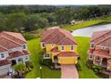 Two-story house with a red tile roof, next to a lake at 4439 Shiva Loop, Kissimmee, FL 34746