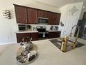 Well-lit kitchen featuring sleek countertops, stainless steel appliances, and wooden cabinets at 446 Citrus Isle Loop, Davenport, FL 33837