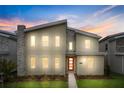 Modern two-story home with red front door, illuminated at night at 4575 Narrative Ln, Kissimmee, FL 34746
