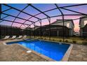 Inviting screened pool and spa area with lounge chairs at 4575 Narrative Ln, Kissimmee, FL 34746