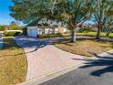 Long brick driveway leading to a charming house with mature trees at 5666 Merlin Way, St Cloud, FL 34772