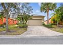 House exterior with a paved driveway and palm trees at 940 Grand Canal Dr, Poinciana, FL 34759