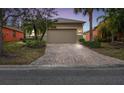 House exterior at dusk with a paved driveway at 940 Grand Canal Dr, Poinciana, FL 34759
