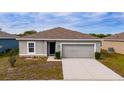 One-story house with a gray exterior, attached garage, and a neatly kept yard at 1067 Haines Dr, Winter Haven, FL 33881