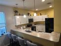 Modern kitchen with white cabinets, granite counters and breakfast bar at 1427 Pacific Rd, Kissimmee, FL 34759