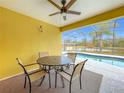 Relaxing patio area with table and chairs overlooking a refreshing pool at 154 Robin Rd, Davenport, FL 33896