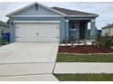 Newly built home with a two-car garage and landscaped yard at 1657 Rosydale Cir, Davenport, FL 33837