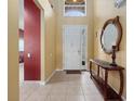 Inviting foyer featuring neutral tile floors, and a stylish wooden console table with decorative mirror at 2615 Pawnall St, Kissimmee, FL 34747