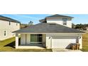 Rear view of house showcasing a garage and sliding glass door to a patio at 2668 Trafalgar Blvd, Kissimmee, FL 34758