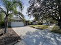 House with a long paved driveway and mature trees at 31 Augusta Cir, St Cloud, FL 34769