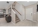 Bright entryway featuring tile flooring, staircase, console table with mirror, and white doors, creating an inviting welcome at 332 Pink Ibis Bnd, St Cloud, FL 34772