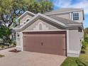 Two-story house with brown garage door and brick driveway at 336 Del Sol Ave, Davenport, FL 33837
