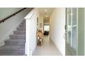 Bright entryway with gray carpeting stairs and tile flooring at 607 Longboat Dr, Davenport, FL 33896