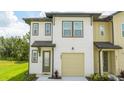 Two-story townhome with neutral siding, attached garage, and front door at 607 Longboat Dr, Davenport, FL 33896