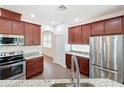Beautiful kitchen features stainless steel appliances and granite countertops with wood cabinets at 6826 Goldflower Ave, Harmony, FL 34773