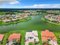 Bird's-eye view of lakefront homes with lush landscaping at 870 Spinnaker Way, Kissimmee, FL 34746