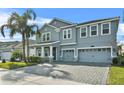 Two-story house with gray siding, three-car garage, and landscaped yard at 8870 Backspin Ln, Champions Gate, FL 33896